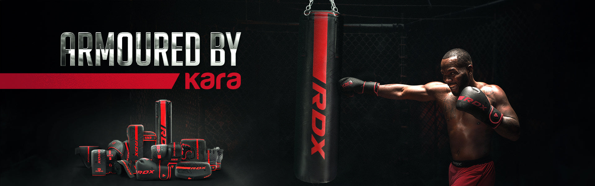 A muscular man in red shorts and black RDX boxing gloves throws a punch at a red and black RDX punching bag in a dark training environment. Below the punching bag is a collection of RDX training gear, including gloves and pads. The text reads 'ARMOURED BY kara' in bold metallic and red font.